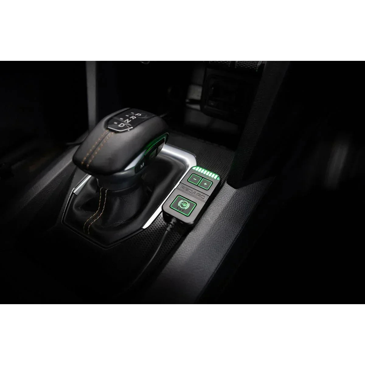 Off-Grid 12V accessory controller installed next to a vehicle gear shifter, illuminated green.