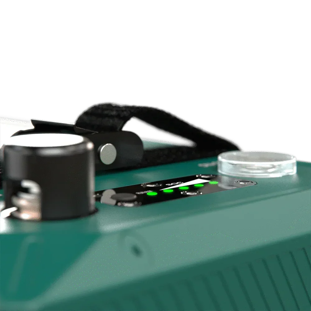 Close-up of a green 12V off-grid battery with LED indicators and handle, vehicle accessory