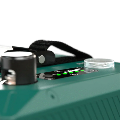 Close-up of a green 12V off-grid battery with LED indicators and handle, vehicle accessory