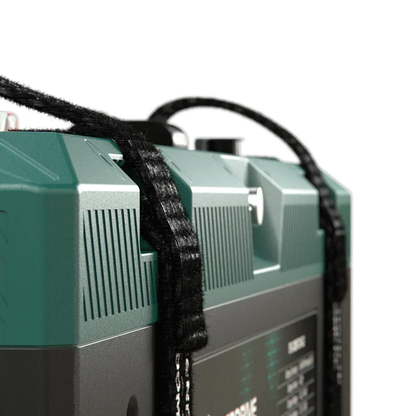 Close-up of a portable 12V off-grid battery box with carry strap and teal top.